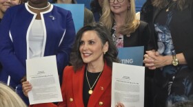 Michigan Governor Gretchen Whitmer holds up legislation she signed into law on February 10, 2026. The laws ban smartphone use in Michigan K-12 classrooms, with a few exceptions.