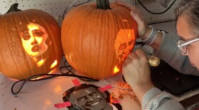 Karrah Youngblood carves a likeness of Steve Inskeep into a pumpkin on Monday, Oct. 14, 2024.