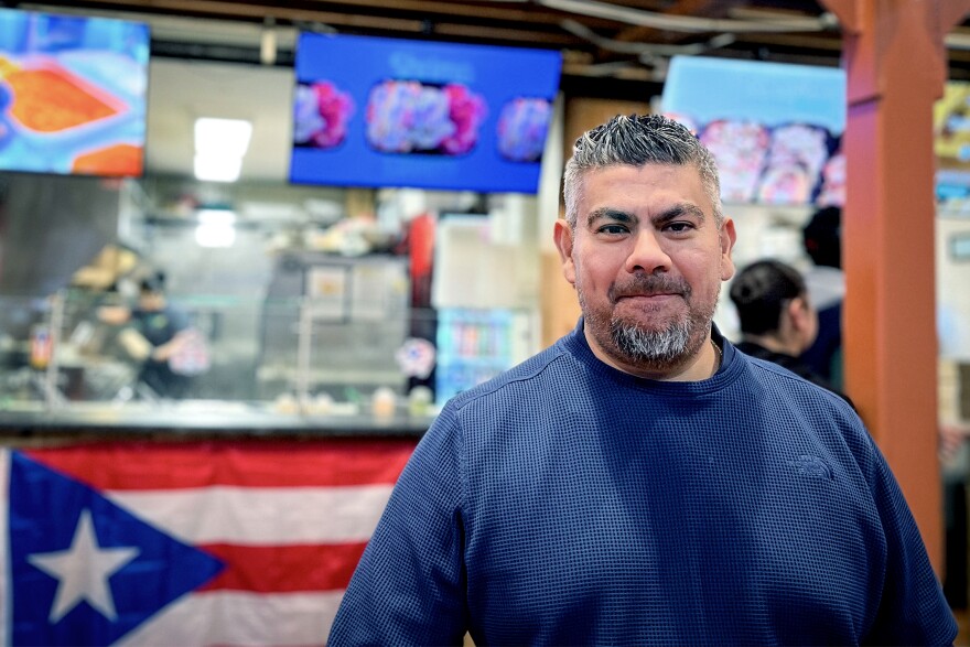 Enrique Rodrigez of Amston, a neighborhood in Hebron, CT, stands in front of Mofongo inside Parkville Market in Hartford, Connecticut on November 10th 2025. He owns the Puerto Rican eatery, as well as Fowl Play. He also opened Las Tortas MX and Burrito Loko inside the marketplace. Rodriguez said he covers the cost of tariffs so his customers don't have to. “For now, we want to take care of the people,” Rodriguez said.