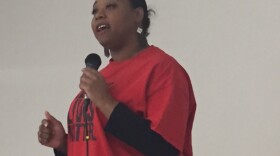 Woman with mic in red Black Lives Matter shirt