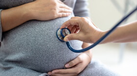 This stock photo shows a doctor using a stethoscop on a pregnant woman with stethoscope. Concept caring for pregnant woman