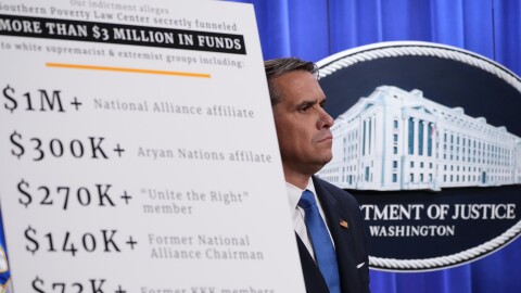 Acting Attorney General Todd Blanche stands behind a sign during a news conference at the Justice Department, Tuesday, April 21, 2026, in Washington.