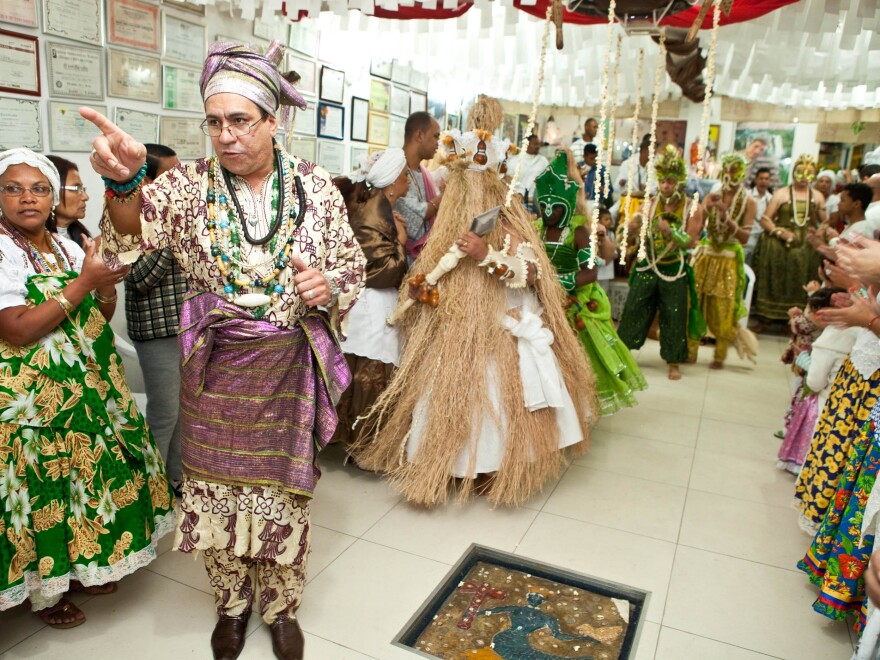 Candomblé priest Pai Nelson guides people who are possessed by orixas, or spirits of deities, back to a Sao Paulo temple, after they changed into orixa costumes.