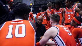 Head Coach Adrian Autry (middle, pullover) coaching his players on the bench during a timeout in Syracuse's loss to Gonzaga.