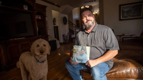 Bradley Cox at his home in Edmond, holding a photo of his wife, Farah.