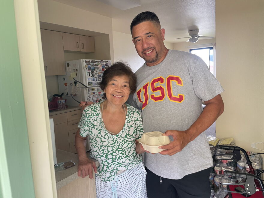 Damian Loo stands with a Kauaʻi resident after delivering a hot meal to her after Hurricane Lowell hit earlier this month.