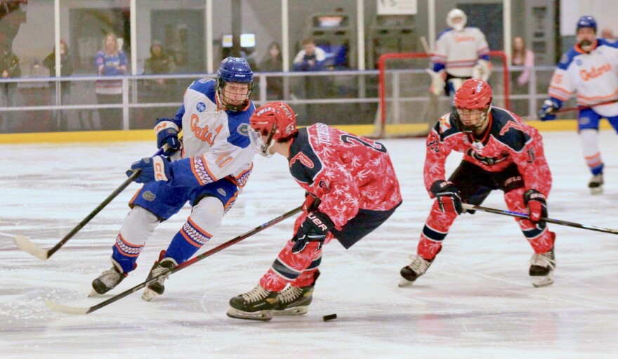 Morton with FAU players engaged on the ice.