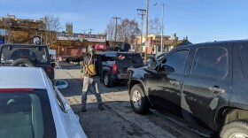 Greg Rowland, a local comic, helps direct traffic and uses his wingspan to ensure cars are parked six feet apart from each other in the parking lot of Chilkoot Charlie's in Anchorage on April 10, 2020. Rowland has been out of work for some time but is happy about how this new stand up comedy event has turned out. (Mayowa Aina/Alaska Public Media)