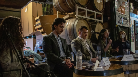 Five KUNR reporters are sitting in a row at an organized panel event at a brewery. One staff member is speaking into a microphone while others look toward her or the crowd, which is out of frame.