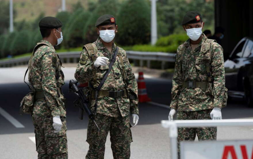 Soldiers in face masks maintain a checkpoint in Putrajaya, Malaysia on Sunday. Malaysian government issued a movement order to the public starting from March 18 until March 31 to stop the spread of the new coronavirus.Vincent Thian/AP
