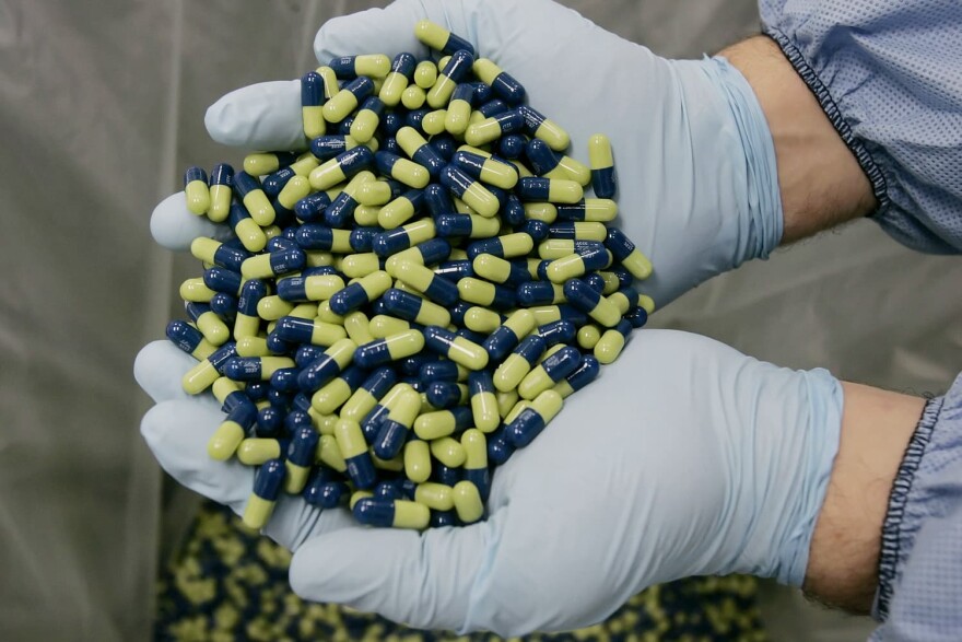 FILE - In this Jan. 25, 2006 file photo, a production technician at Eli Lilly and Company, examines Cymbalta 60mg pills in Indianapolis. The Food and Drug Administration has posted its review of Eli Lilly and Co.'s application to market the drug for a range of pain ailments, including lower back pain. FDA reviewers have questions about the statistical methods used to study the drug and liver side effects. (AP Photo/Darron Cummings, File)