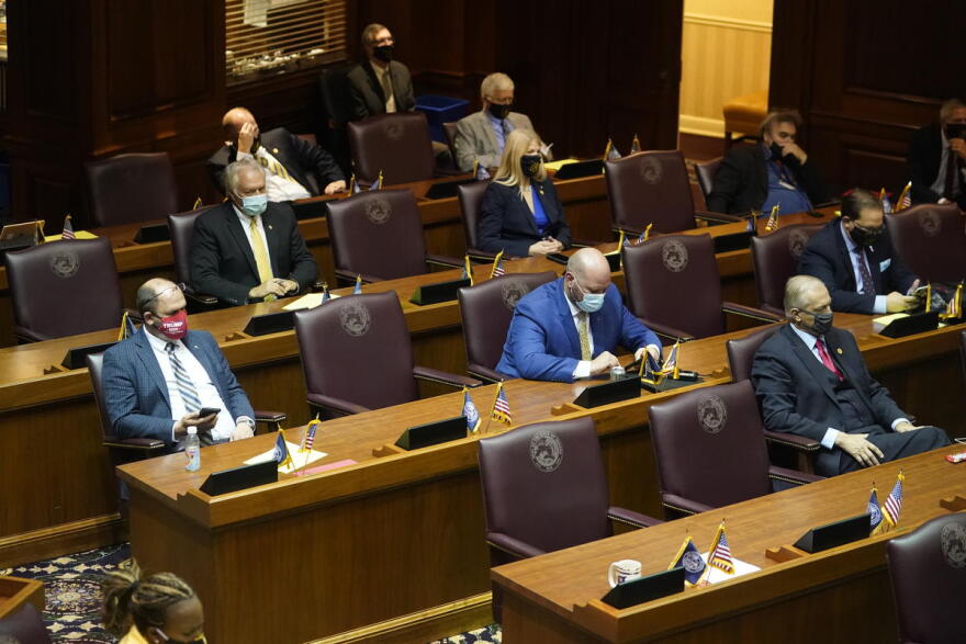 Lawmakers on the House floor for the ceremonial beginning of session were spaced out and wearing masks.