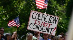 A demonstrator holds a sign at a rally outside the Indiana Statehouse in September opposing any COVID-19 vaccine requirements.