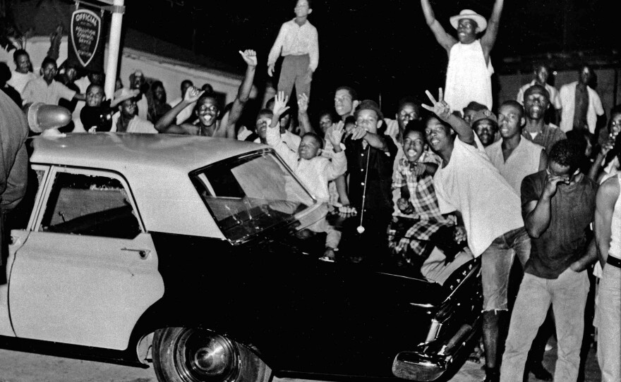 Demonstrators push against a police car in the Watts district of Los Angeles on Aug. 12, 1965. The Watts riots raged for most of a week. When the smoke cleared, 34 people were dead, more than 1,000 were injured and hundreds of buildings were destroyed.