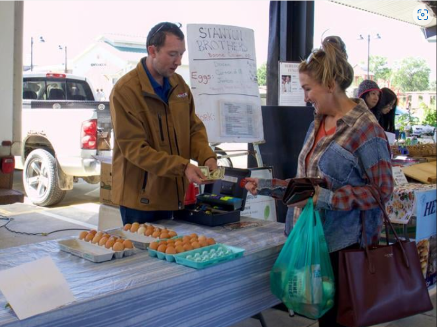 Dustin Stanton sells eggs to first time customer Melinda Buerky on Sept. 7 at the Columbia Farmers Market. She drove in from Kansas City to buy fresh farm eggs because "they taste fresher and heartier."