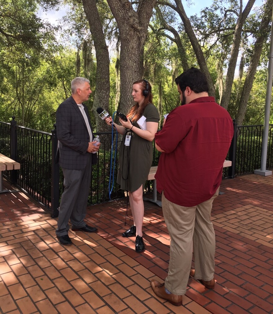 A pair of interns interview a man. 