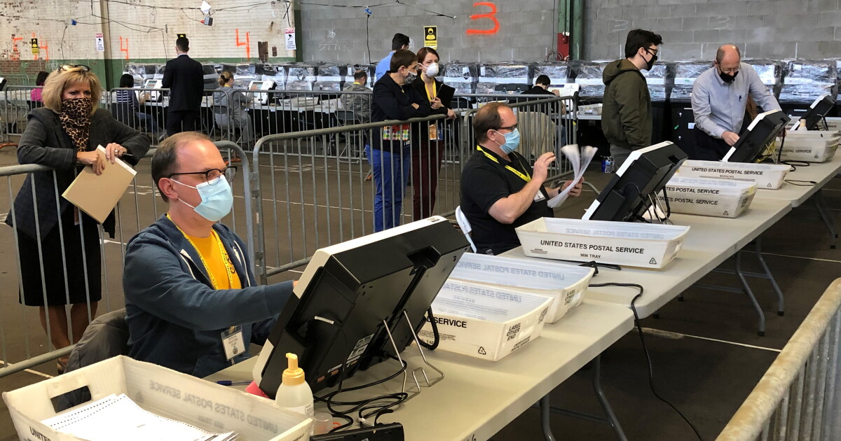 Election workers process mail ballots in November 2020.
