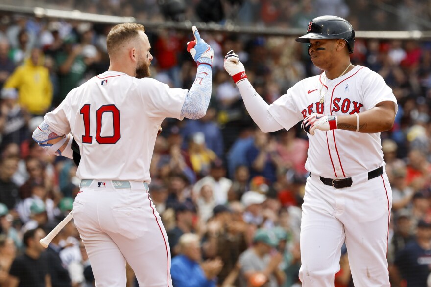 Boston Red Sox's Rafael Devers, right, celebrates with shortstop Trevor Story (10) after hitting a solo home run in the fifth inning of a baseball game against the New York Yankees, Sunday, June 15, 2025, in Boston. (AP Photo/Greg M. Cooper)