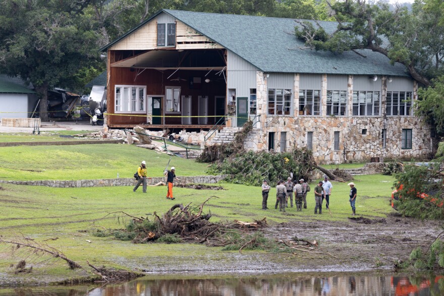 Law enforcement agents outside of a damaged building at Camp Mystic on Sunday, July 6, 2025.
