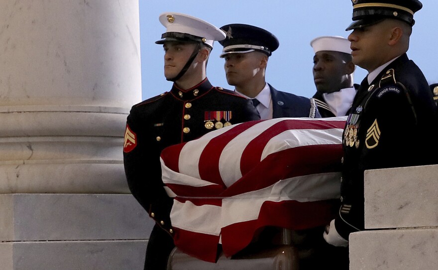 The flag-draped casket of former President George H.W. Bush is carried by a joint services military honor guard to lie in state in the rotunda of the U.S. Capitol, Monday, Dec. 3, 2018, in Washington. 