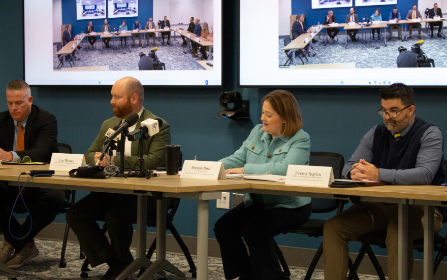 Task force members sit together at a table, 