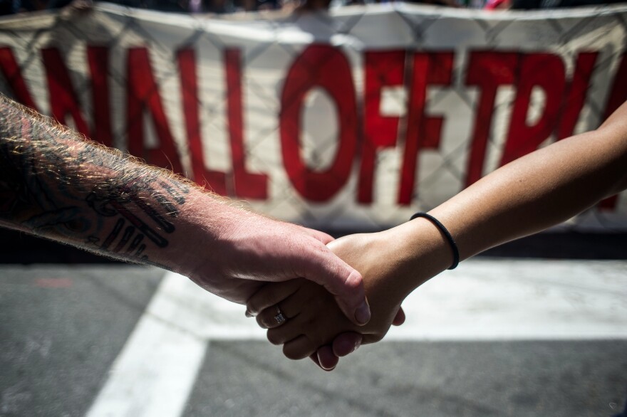 Protesters link hands during a demonstration against Republican presidential nominee Donald Trump in front of the Quicken Loans Arena on Wednesday.