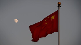 The Chinese flag is seen in front of a view of the moon at Tiananmen Square in Beijing on Dec. 13, 2013. (Mark Ralston/AFP/Getty Images)