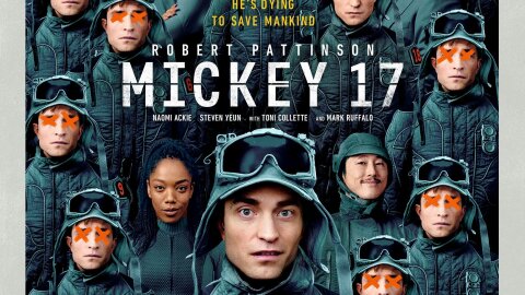 Several soldier looking people in blue grey uniforms crowd a poster for the movie Mickey 17.