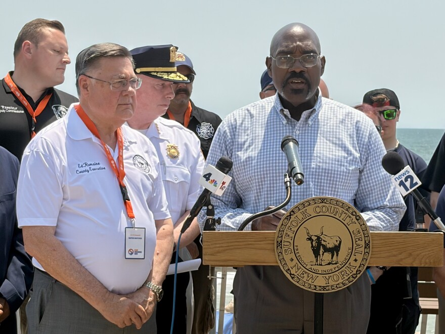 Suffolk County Health Commissioner Dr. Gregson Piggot (right) offers tips to stay safe during the heat wave at a news conference at Smith Point Beach in Shirley, NY, on June 30, 2026.