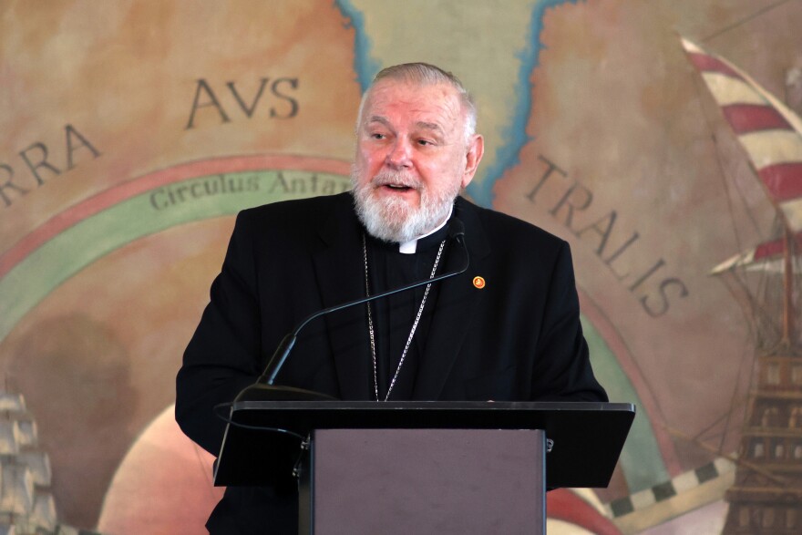 A Catholic archbishop speaks at a podium 