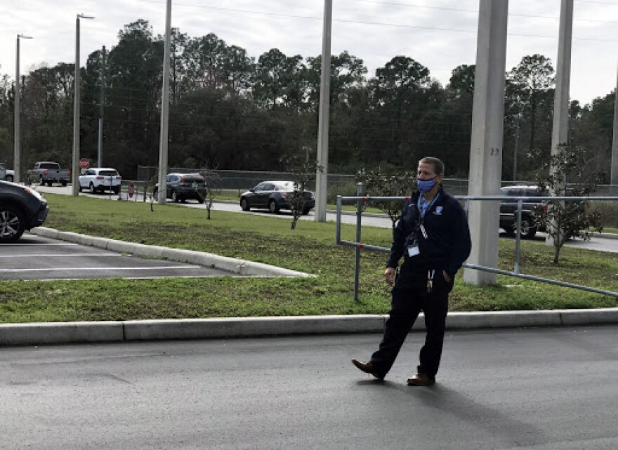 Matt McDermott supervisa el tráfico estudiantil de Wesley Chapel High School Feb. 16. (foto por Amy Galo)