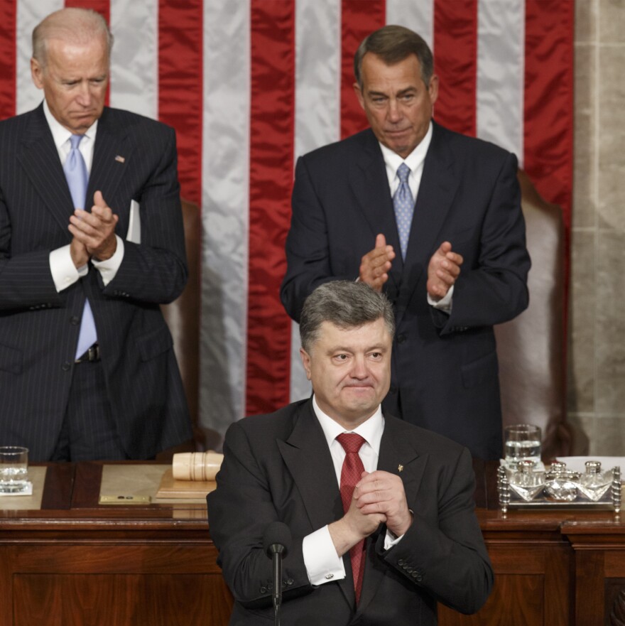 Ukrainian President Petro Poroshenko, joined by Speaker of the House John Boehner and Vice President Joe Biden,  acknowledges lawmakers' applause after addressing a joint meeting of Congress.