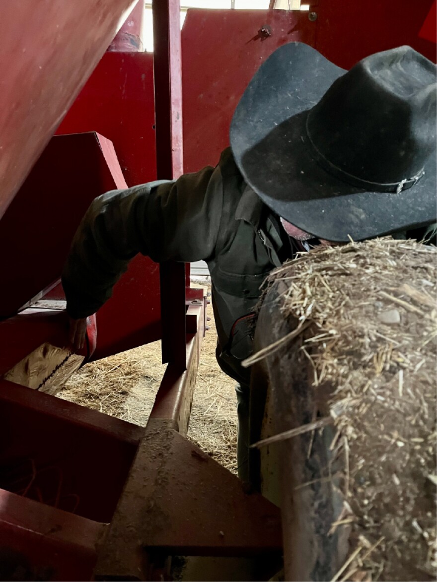 Rancher Lamont Herman checks on repairs he and his son made to a vintage grain grinder