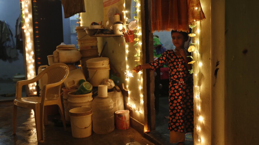 A girl plays with firecrackers during Diwali on Sunday in New Delhi. Hindus light lamps, wear new clothes, exchange sweets and gifts and pray to the goddess Lakshmi during Diwali, the festival of lights.