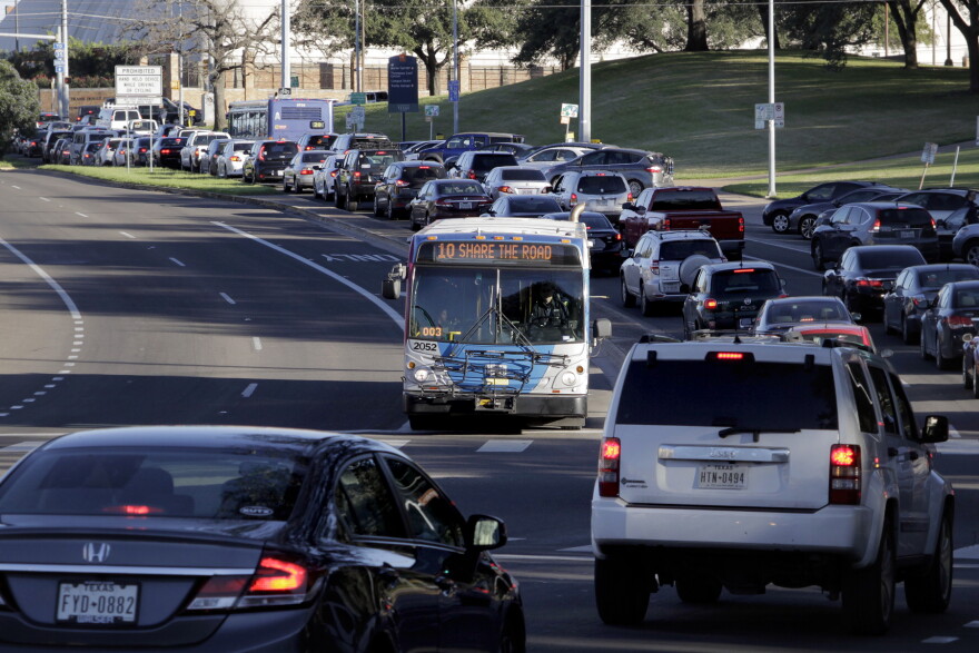 A CapMetro bus waiting to make a left-hand turn in busy traffic