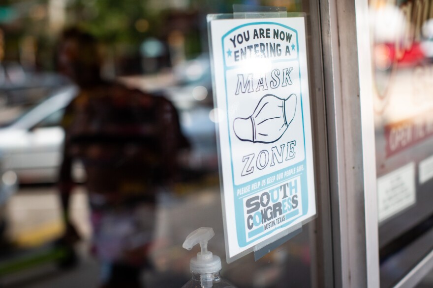 A sign outside of a store on South Congress Avenue notifies patrons to wear masks. 