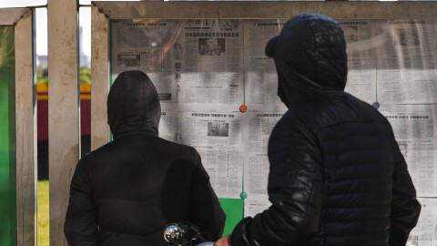 Residents read local newspapers at a newsstand as one of them reports China cites Japanese Prime Minister Sanae Takaichi's recent remarks, "erroneous," in Beijing, Monday, Nov. 17, 2025. (AP Photo/Andy Wong)