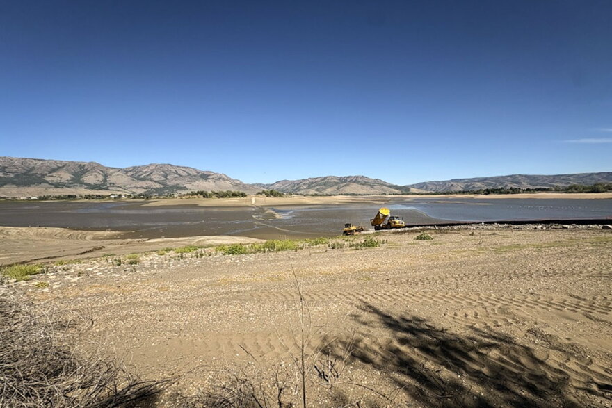 Crews haul rocks to build a temporary road across Pineview Reservoir, Sept. 14, 2026.