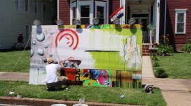 John Romang works on a mural at the festival.