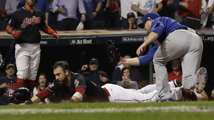 The Indians' Jason Kipnis scores, evading a tag by Jon Lester during the fifth inning.