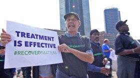 Man holding a sign saying recovery matters