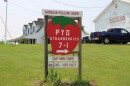 A "pick your own strawberries" sign, shaped like a strawberry. 