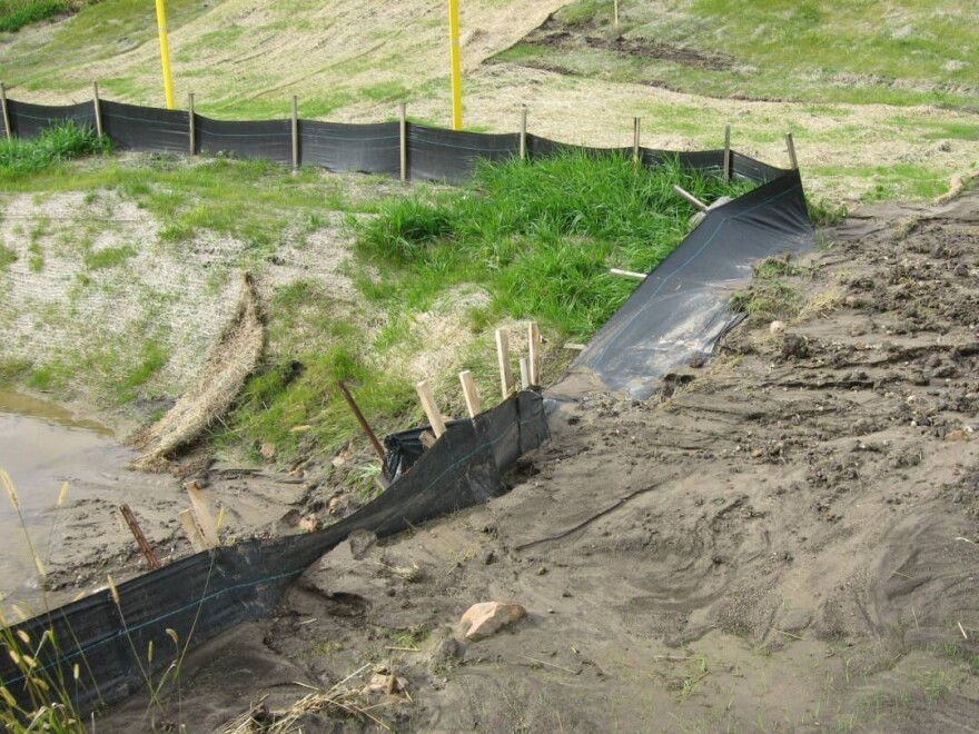 Sediment from a construction site washes over a silt fence and into a waterway. These fences are one way construction companies try to keep water pollution from happening.