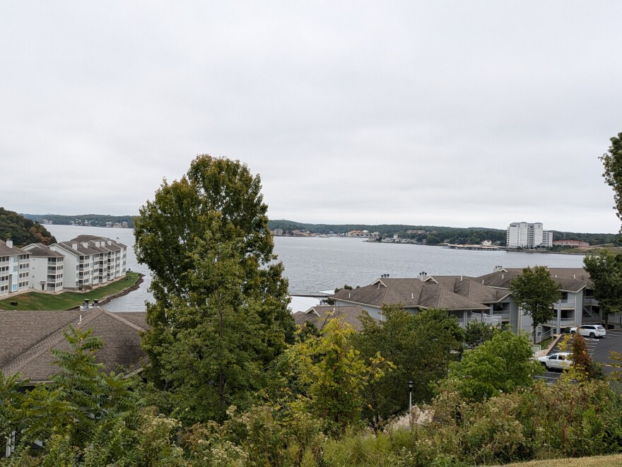 A line of condos overlooking the lake. It's an overcast day and the lake is quiet.