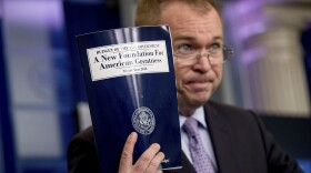 Budget Director Mick Mulvaney holds up a copy of President Trump's proposed fiscal 2018 federal budget at the White House on Tuesday.