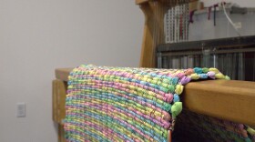 A woven rug sitting on a loom