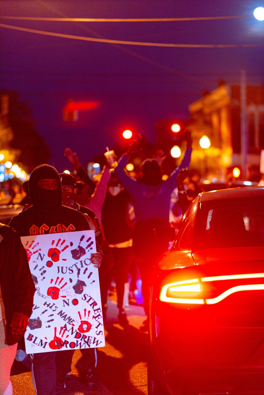 A driver of a vehicle in Elizabeth City on April 26, 2021 raises her fist in support of the protestors and was welcomed graciously with raised arms and chants.