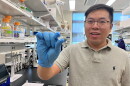 Researcher Penghui Zhao holds up a wearable medical device that can prevent accidental opioid overdoses.