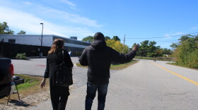 Dannick Massamba-Bankela waves at supporters as he walks into ICE's Scarborough field office with his lawyer on Tuesday, Sept. 22, 2026.