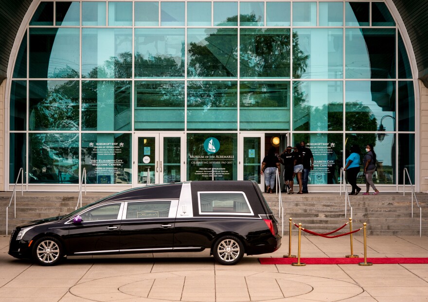 Employees of Horton's Funeral Home escort the casket of Andrew Brown Jr., into the Museum of the Albemarle in Elizabeth City, NC. Andrew Brown Jr., a 42-year-old Black man, was shot five times, including once in the back of the head, when Pasquotank County deputies tried to serve drug-related search and arrest warrants at his home April 21. (Kate Medley / WUNC)